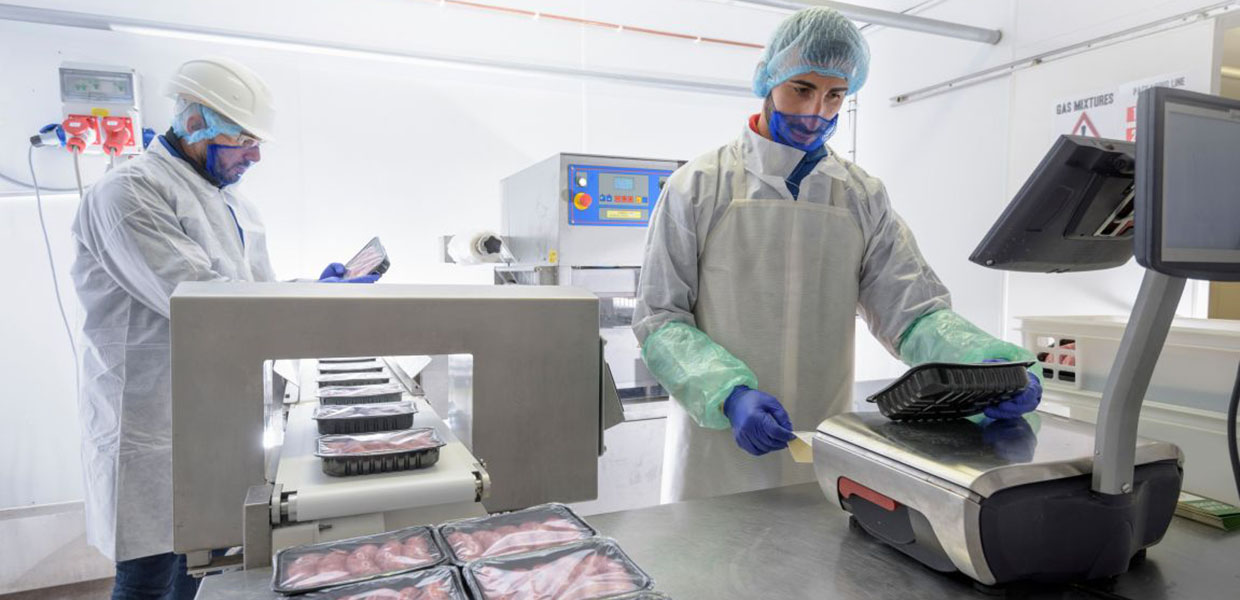 Food workers in a meat packaging facility